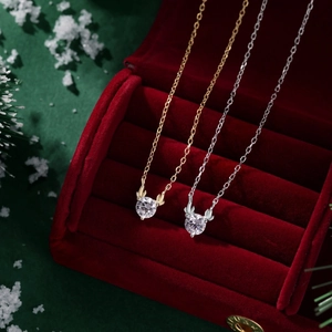 Close-up of gold and silver reindeer antler necklaces in a red velvet gift box