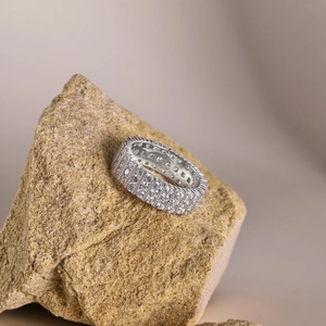 Macro view of multi-row pavé cubic zirconia ring set on a raw natural stone