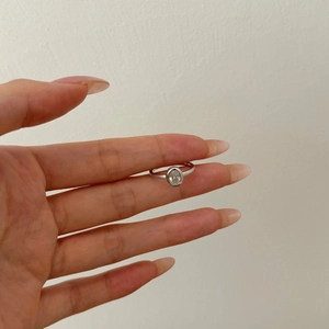 Macro shot of an oval-cut cubic zirconia inlaid in a minimalist 925 sterling silver ring