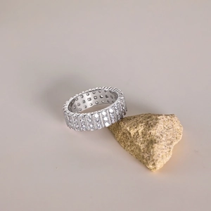 Macro shot of three-row eternity ring with cubic zirconia stones on textured rock