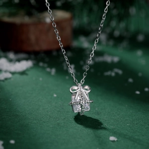 Detailed close-up of a silver gift box pendant with a large rectangular gemstone and bow