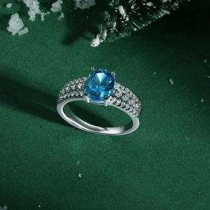 Macro detail of oval blue gemstone ring with pave diamonds on green festive background