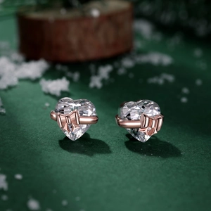 S925 zilveren hart oorknopjes met strik en zirkonia in een feestelijke winterse setting