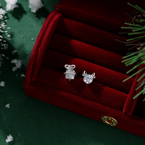 Close-up of S925 silver reindeer and gift box earrings in a festive velvet jewelry box