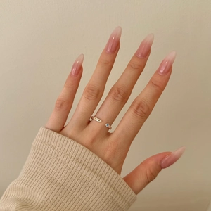 Detail of silver S925 ring with zircon stones on model hand with knit sweater