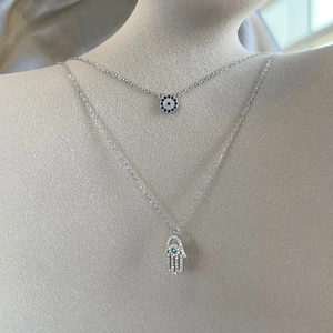 Layered 925 silver necklace featuring Hamsa Hand and Evil Eye charms with blue zircon stones