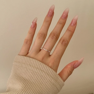 Close-up of S925 silver ring with colorful zircons worn on model finger over knit sleeve