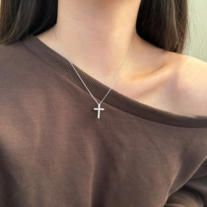 Detailed view of an S925 sterling silver cross pendant necklace with zircon stones on a neck