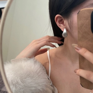 Gros plan sur un clou d'oreille en argent S925 avec une finition métallique brossée mate