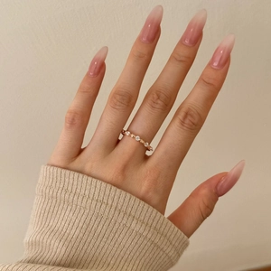 Close-up of rose gold silver ring with heart-shaped zirconia stones on model finger