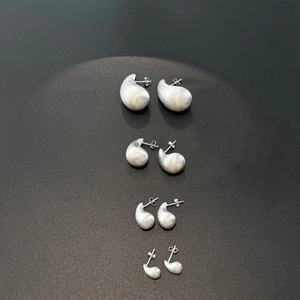 Gros plan de boucles d'oreilles goutte en argent S925 avec finition mate brossée en quatre tailles