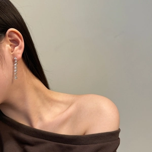 Detail of luxury S925 silver fringe earrings with shimmering cubic zirconia on model