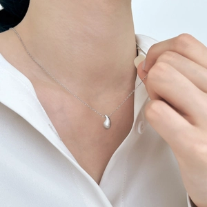 Gros plan du pendentif fève en argent sterling S925 avec finition mate brossée