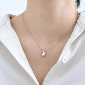Détail du collier pendentif haricot en argent sterling S925 brossé sur chemise