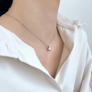 Détail du pendentif en argent sterling S925 avec texture en métal brossé porté par un mannequin