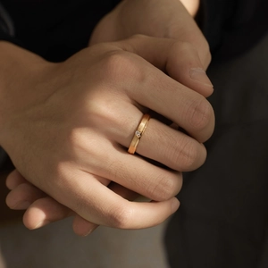 Gros plan d'une bague en argent brossé doré avec zircon sur un modèle masculin au soleil