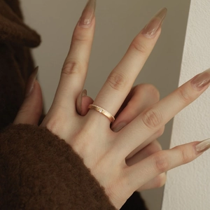 Bague en or rose mat avec micro-sertissage de zircons et diamant central sur la main