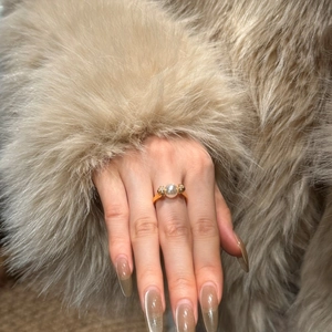 Close-up of elegant 8mm pearl ring with gold band and zircon accents on a model