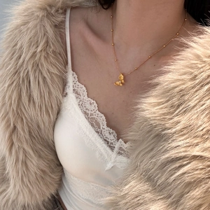 Detailed view of a gold-plated 925 silver butterfly necklace with small beaded chain
