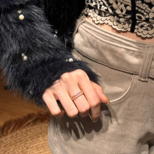 Close-up of gold band ring featuring sparkling pink and purple pavé cubic zirconia