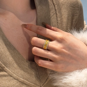 Close-up of golden wheat leaf ring with double row of white diamonds in high detail