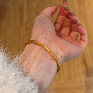 Nahaufnahme des mattgoldenen S925 Silberarmbands mit strukturierter Oberfläche und Zirkonia