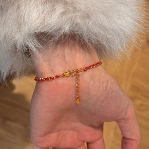 Detail of red rope and gold chain braided bracelet with S-hook and adjustable clasp