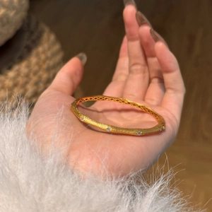 Nahaufnahme eines goldenen Armreifs mit Zirkonia-Inlay und Waben-Innenstruktur