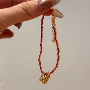 Detailed close-up of S925 hallmark on a red braided bracelet with gold gourd charm