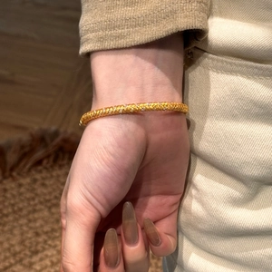 Close-up of a 22K gold-plated S925 silver woven bangle with sparkling zircon inlay
