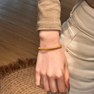 Macro shot of 22K gold plated silver snake pattern bangle with zircon stones on wrist