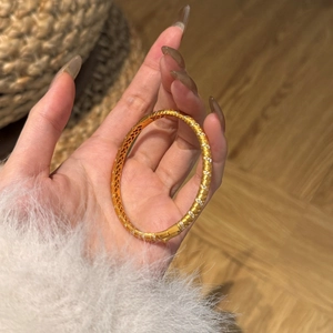 Close-up of golden S925 silver bracelet with sparkling zircon stones and lattice texture
