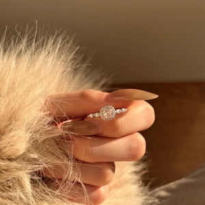 Detail of pink cushion-cut silver ring with micro-pave diamonds on model hand