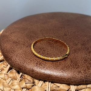 Golden S925 silver bangle with brushed finish and inlaid pavé zircon wave patterns