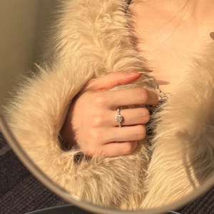 Close-up of S925 silver halo ring with pink gemstone and pavé diamonds on model