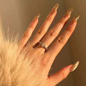 Detail of S925 silver heart ring with pink 8A zircon stone worn on a finger