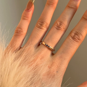 Vista dettagliata di un anello in oro martellato con cinque zirconi blu tondi