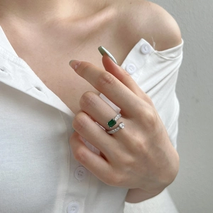 Close-up of S925 silver Toi et Moi ring with emerald cut green stone and side diamonds