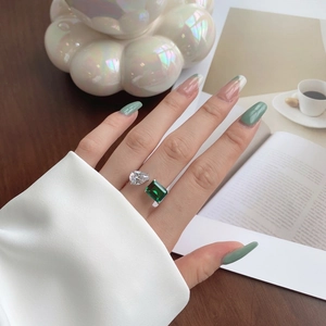 Gros plan d'une bague en argent S925 sertie de pierres blanche et verte émeraude