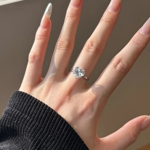Close-up of a heart-shaped diamond ring in S925 sterling silver on a female hand