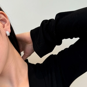 Detail of silver S925 sterling silver hoop earrings with pavé zircons on a model