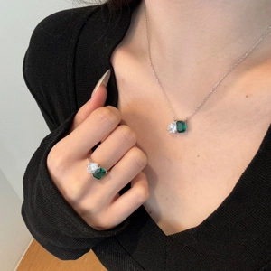 Gros plan d'un ensemble collier et bague en argent S925 avec pierres émeraude et goutte