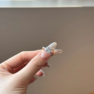 Detail of the six-prong setting holding a brilliant round white zircon on a silver ring