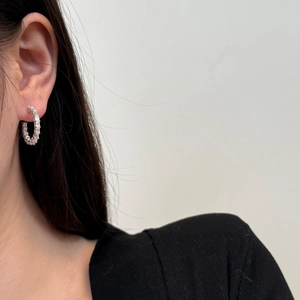 Close-up of elegant S925 sterling silver C-shaped earrings with baguette-cut zircons