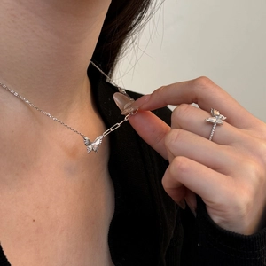 Detail van zilveren vlinderketting en gevlochten ring set met sprankelende zirkonen