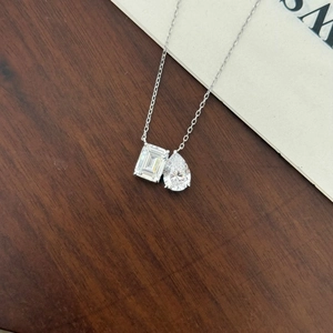 Détail du pendentif à double pierre taille émeraude et poire sur une chaîne en argent