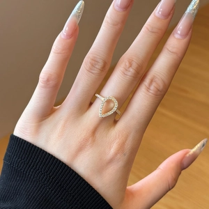 Detailed view of an openwork pear-shaped ring with micro-set stones on a finger