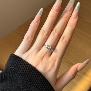 Close-up of sparkling S925 silver ring with a single round cut stone on a hand