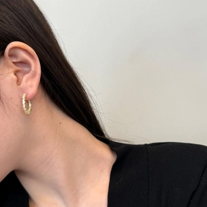 Detail of S925 silver gold hoop earrings with baguette-cut cubic zirconia on model