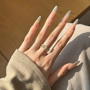 Close-up of three-piece marquise-cut gold ring set with micro-pave stones on fingers